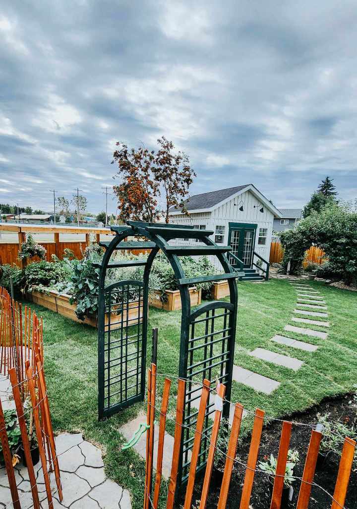 A backyard with a garden cottage and 3 raised beds.
