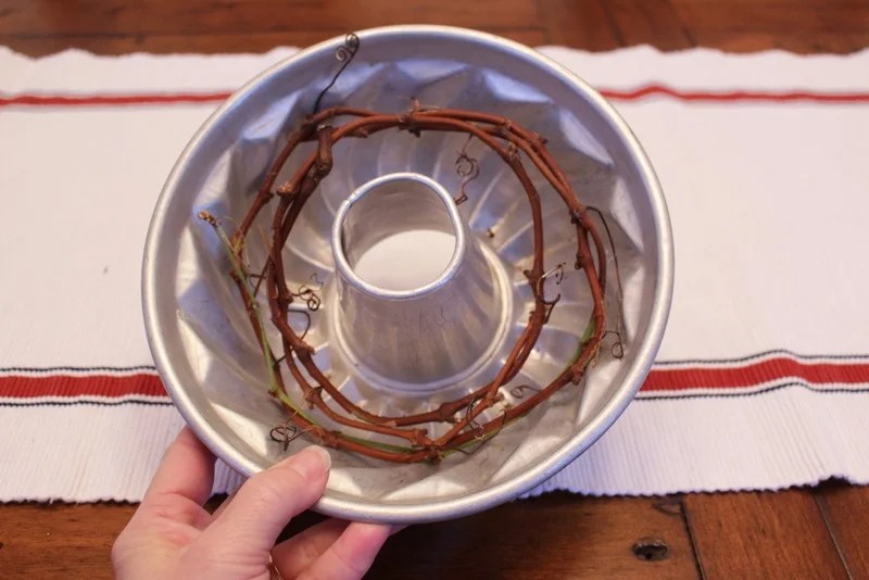 A bundt pan with a small ring of grapevines to keep the birdseed wreath from falling apart.