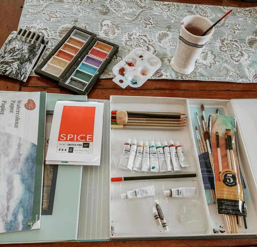 Watercolour booklet, pad, paints, and brushes, all set up to get started painting Christmas cards. 