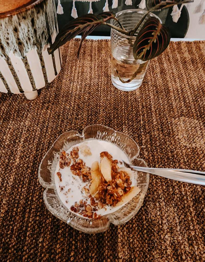 A bowl of apple crisp with heavy cream.