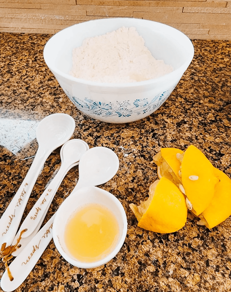 A bowl of dry ingredients, lemon juice, and some squeezed lemons... the ingredients for a lovely lemon cake. 