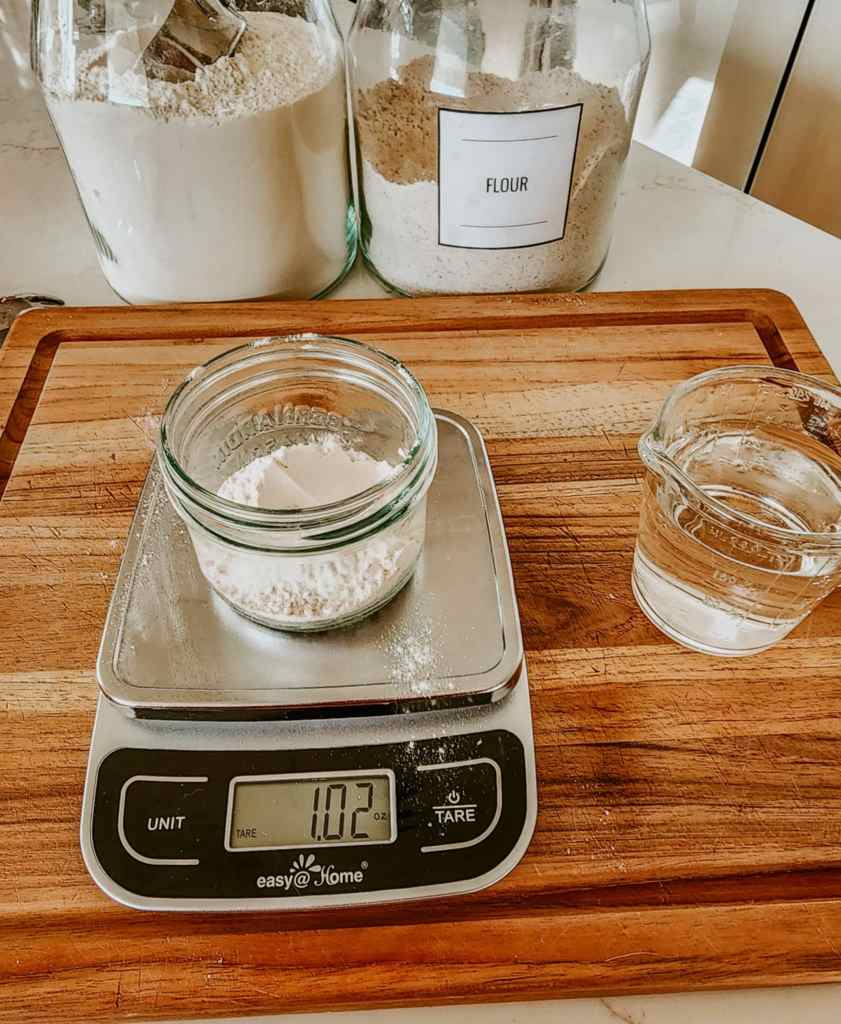 A kitchen scale with a mason jar of flour on it. 