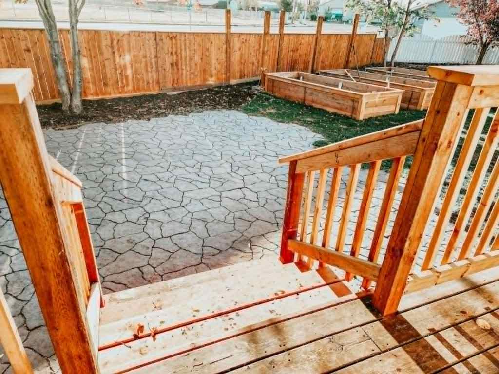 New wooden raised beds and a newly laid irregular interlock stone patio. 