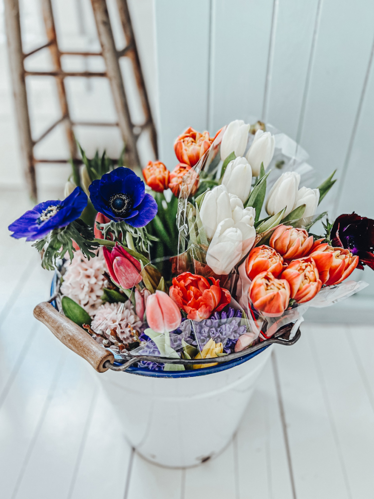 A big white enamel bucket of spring blooms. 