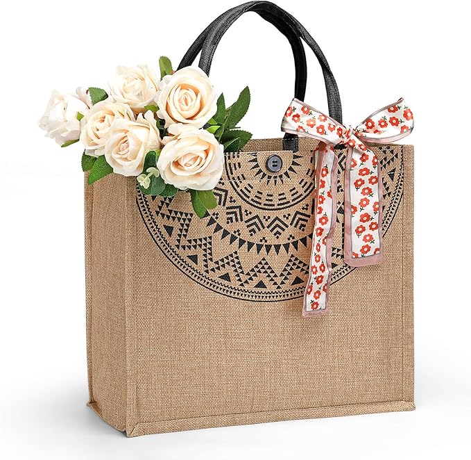A decorative tote bag made of burlap, featuring a patterned design, with a bouquet of white roses and a floral ribbon tied as embellishment.