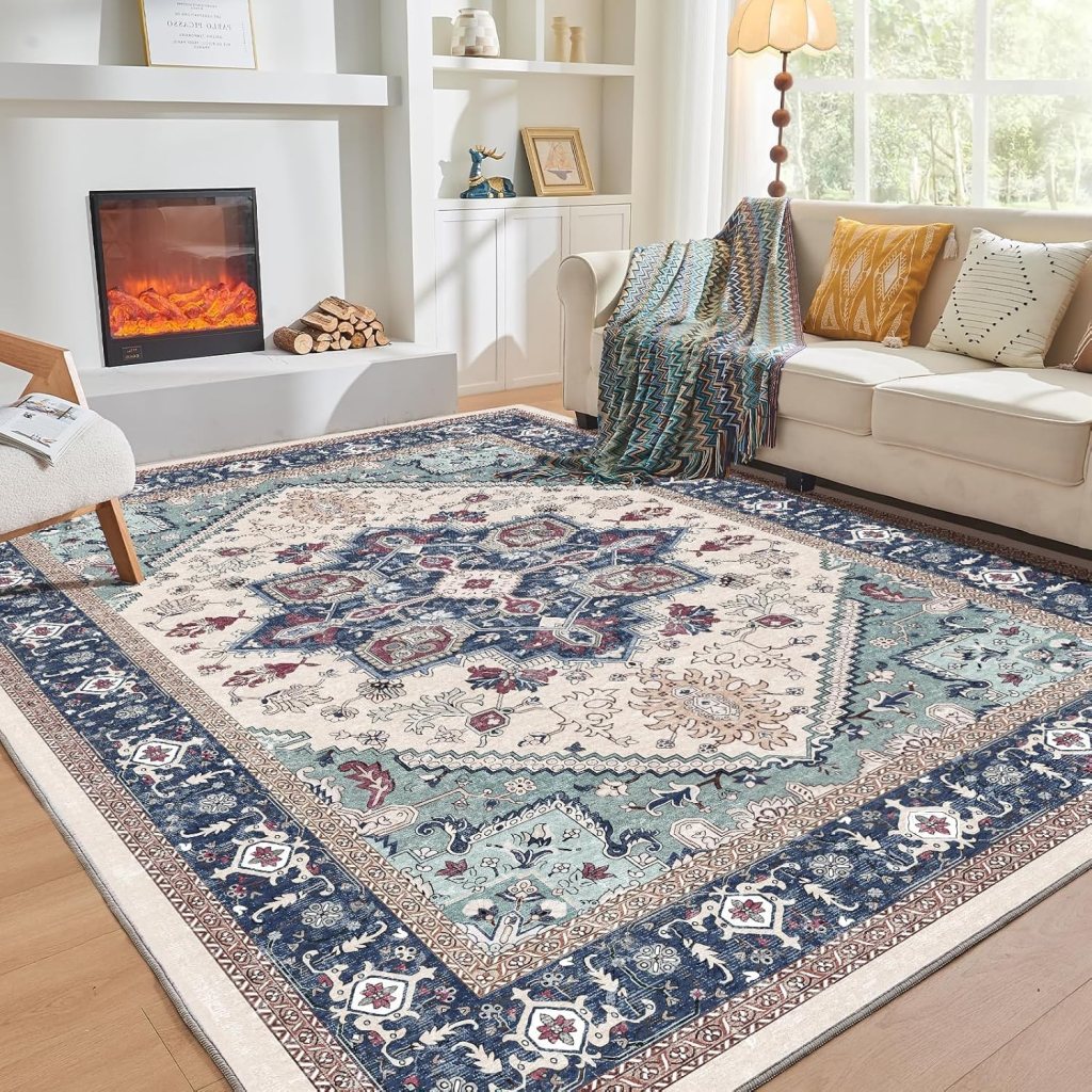 A large ornate area rug with a cream base, featuring intricate blue and red floral patterns, placed in a cozy living room with a bright window, comfortable couch, and a warm fireplace.