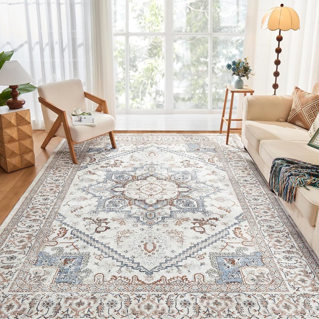 A stylish area rug with an intricate design, featuring shades of blue and beige, placed on a wooden floor in a bright living room with large windows and modern furniture.