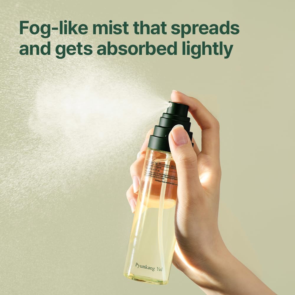 A hand holding a spray bottle, releasing a fine mist against a soft green background, showcasing a skincare product.
