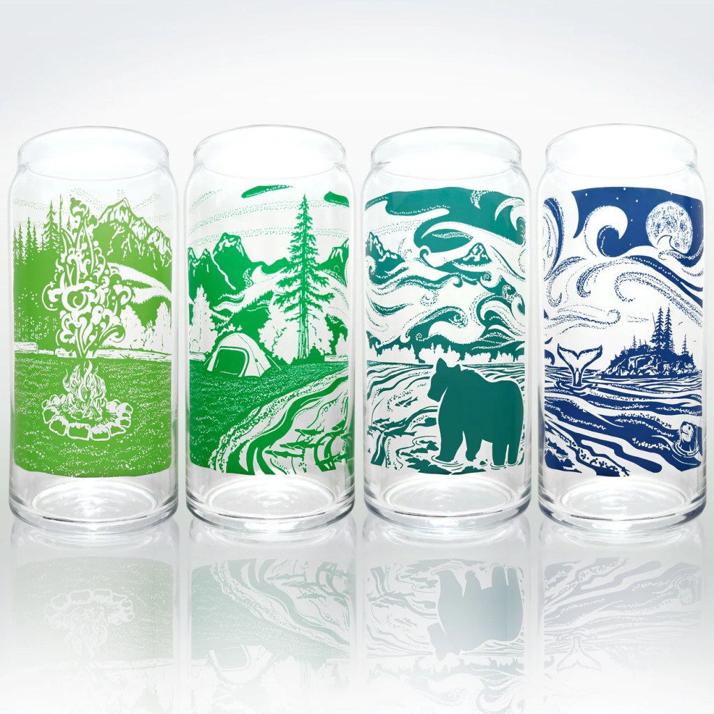 Four illustrated glass tumblers featuring outdoor designs including a campfire, mountains, forest, and wildlife.