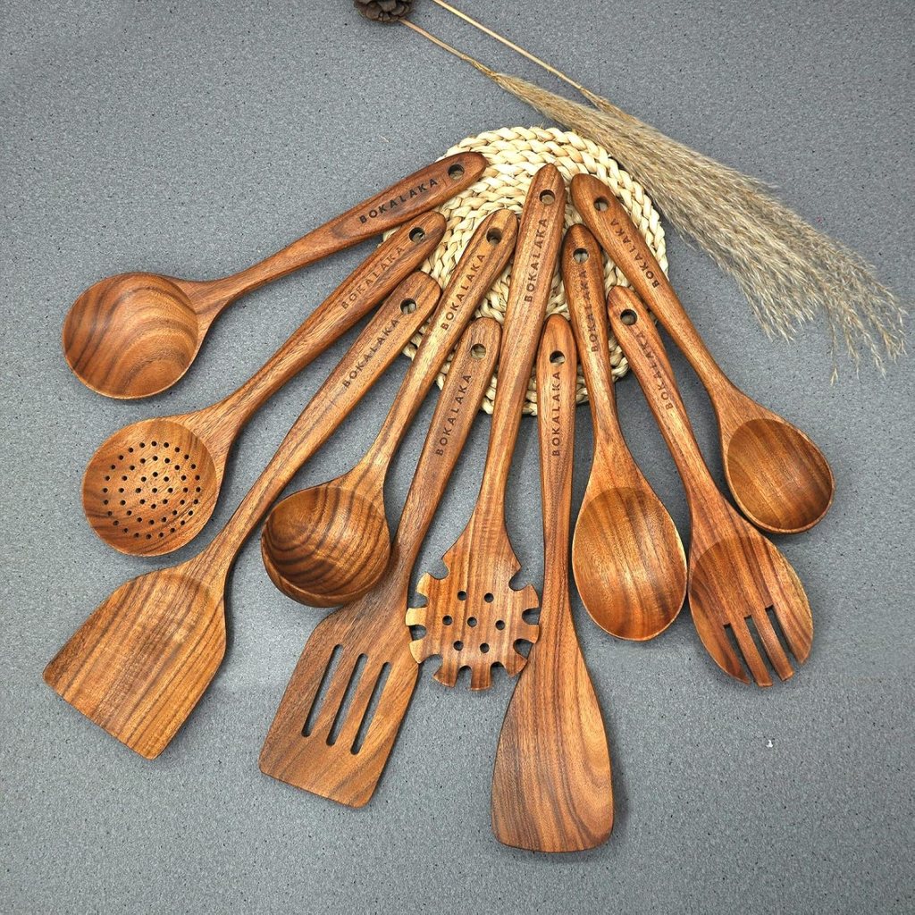 A collection of wooden cooking utensils arranged in a circular pattern on a gray surface, showcasing various types including ladles, spatulas, and slotted spoons.