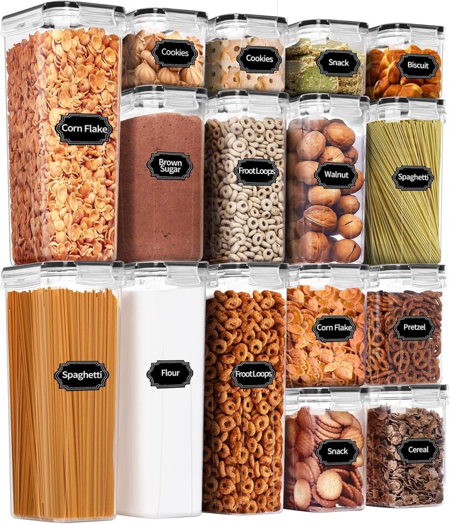 A collection of labeled transparent food storage containers filled with various snacks, cereals, and ingredients such as corn flakes, cookies, flour, and pasta.