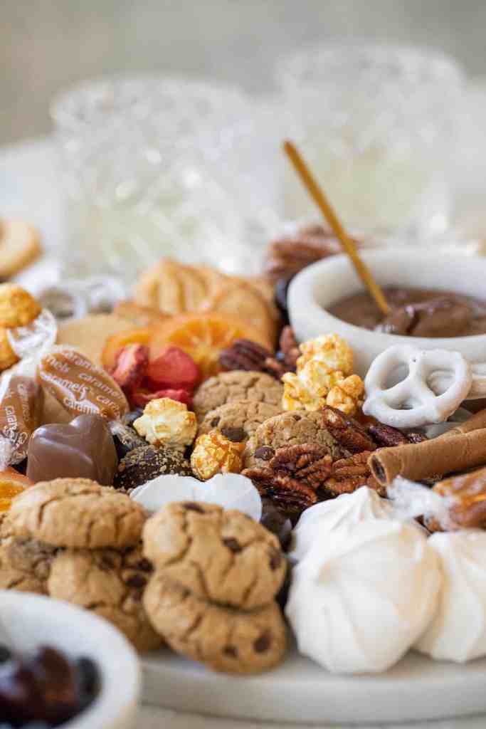 A dessert charcuterie board with chocolate sauce and yummy goodies. 
