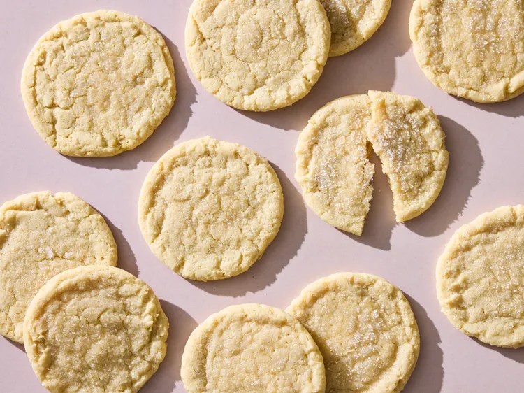 Lemon sugar cookies on a mauve tabletop. 