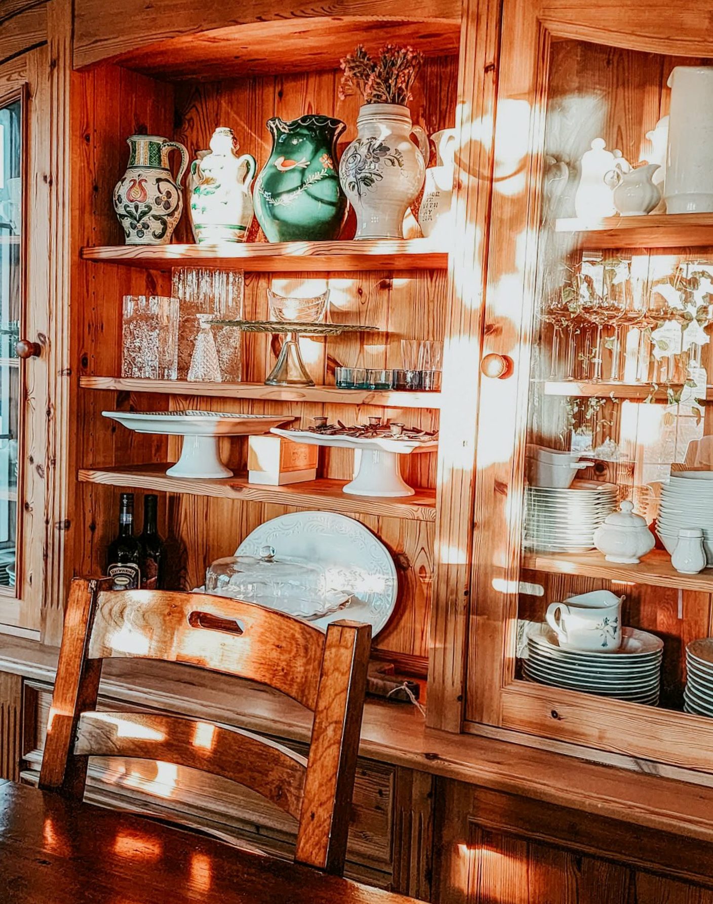 A wooden cabinet with vases, pottery, Iittala glass, and ceramics.