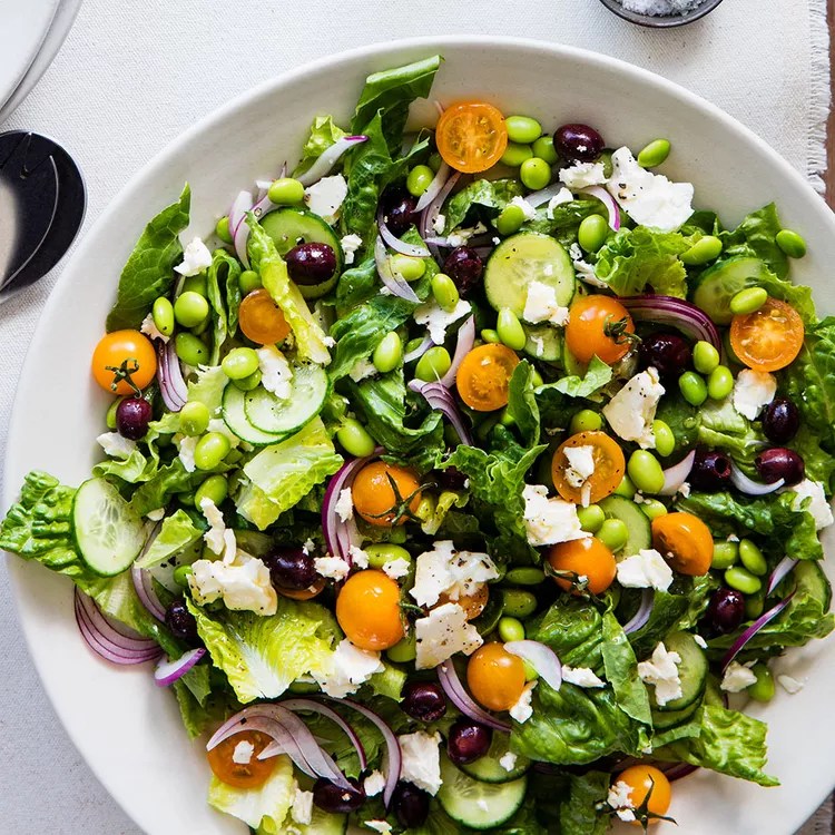 A Greek salad with orange cherry tomatoes.